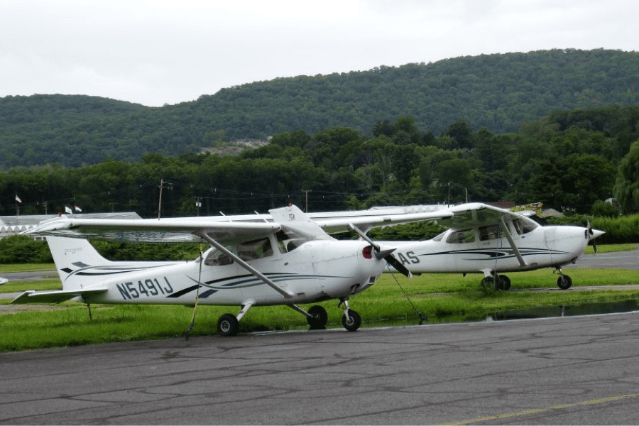 A couple of small airplanes parked on top of grass.