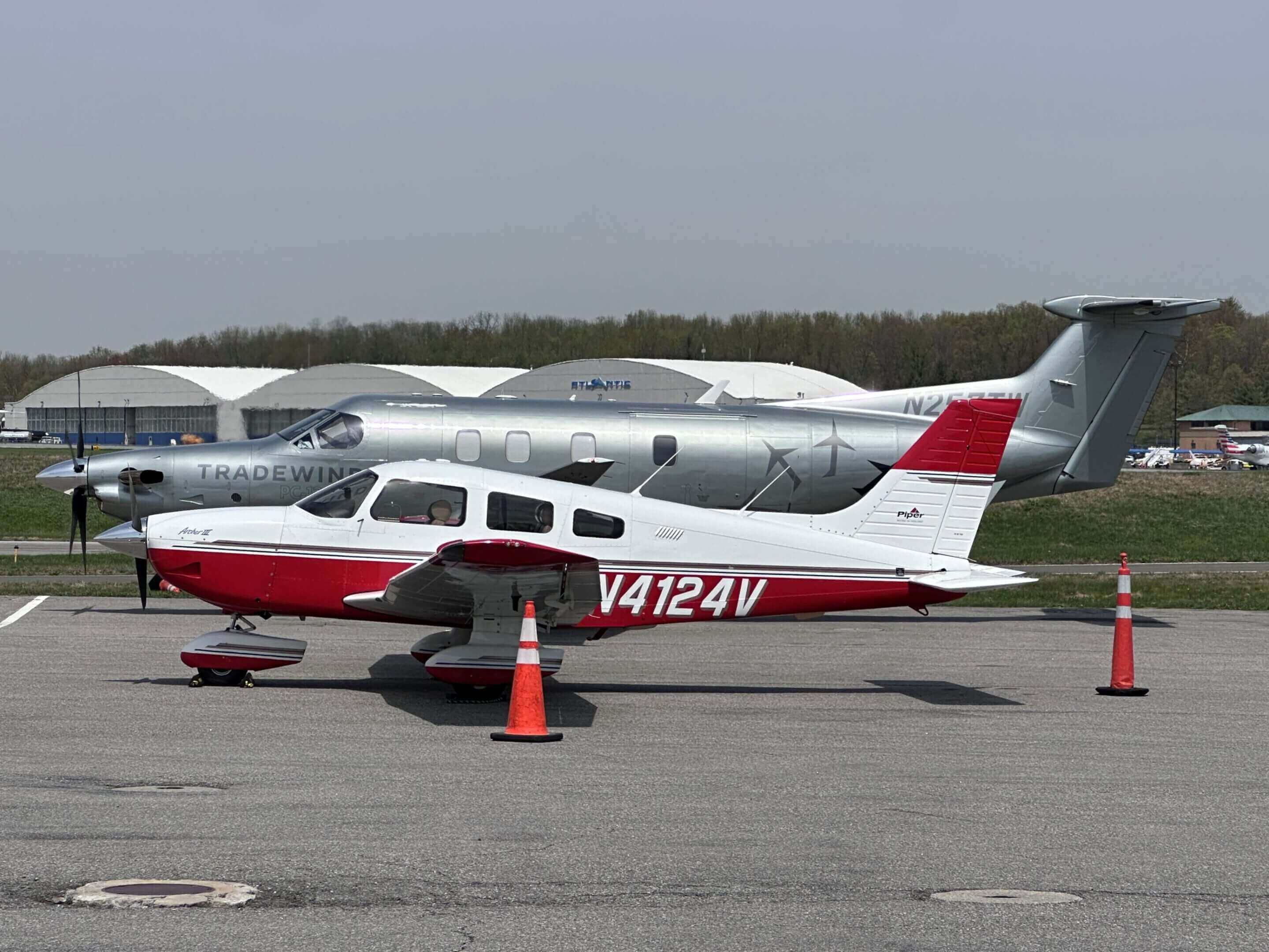 Two small airplanes parked near hangars.