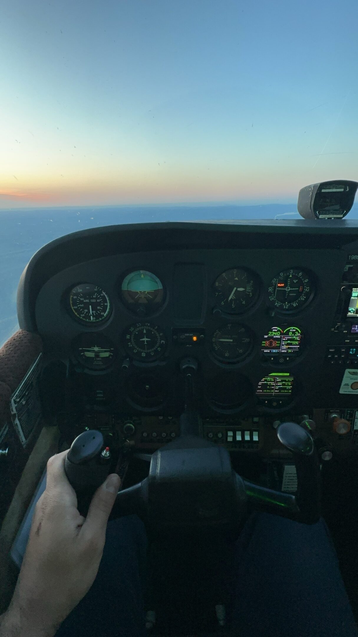Cockpit view of airplane during sunset flight.