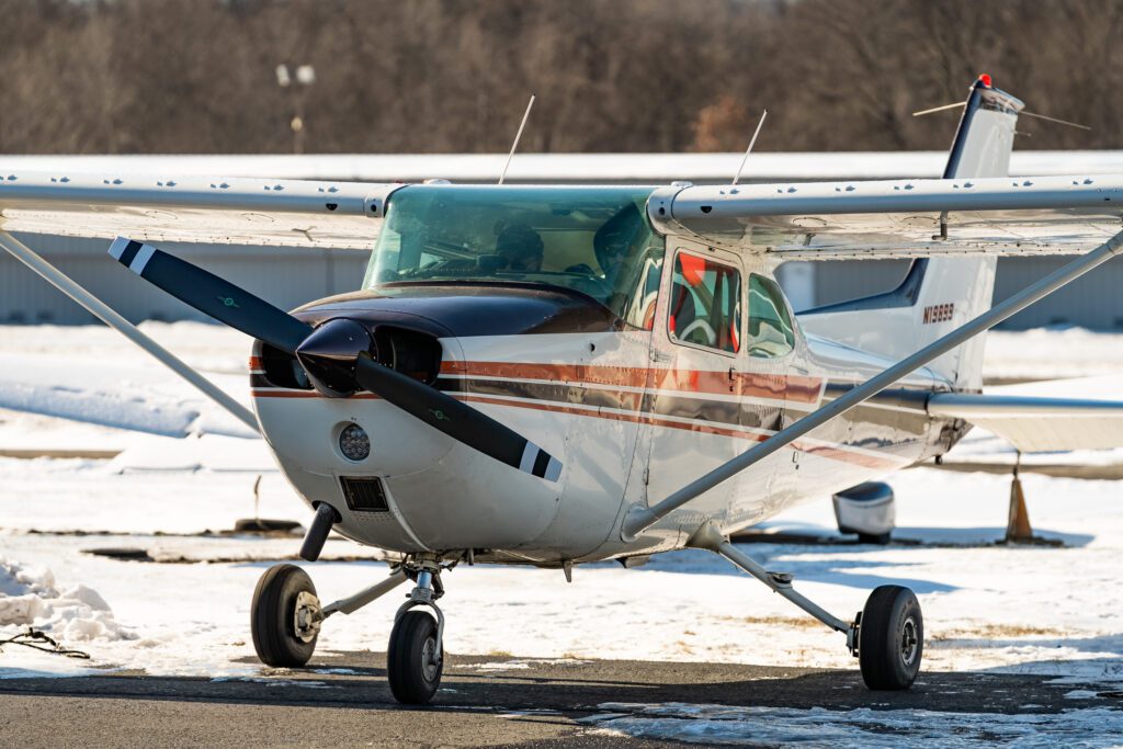 Small airplane parked on snowy tarmac.