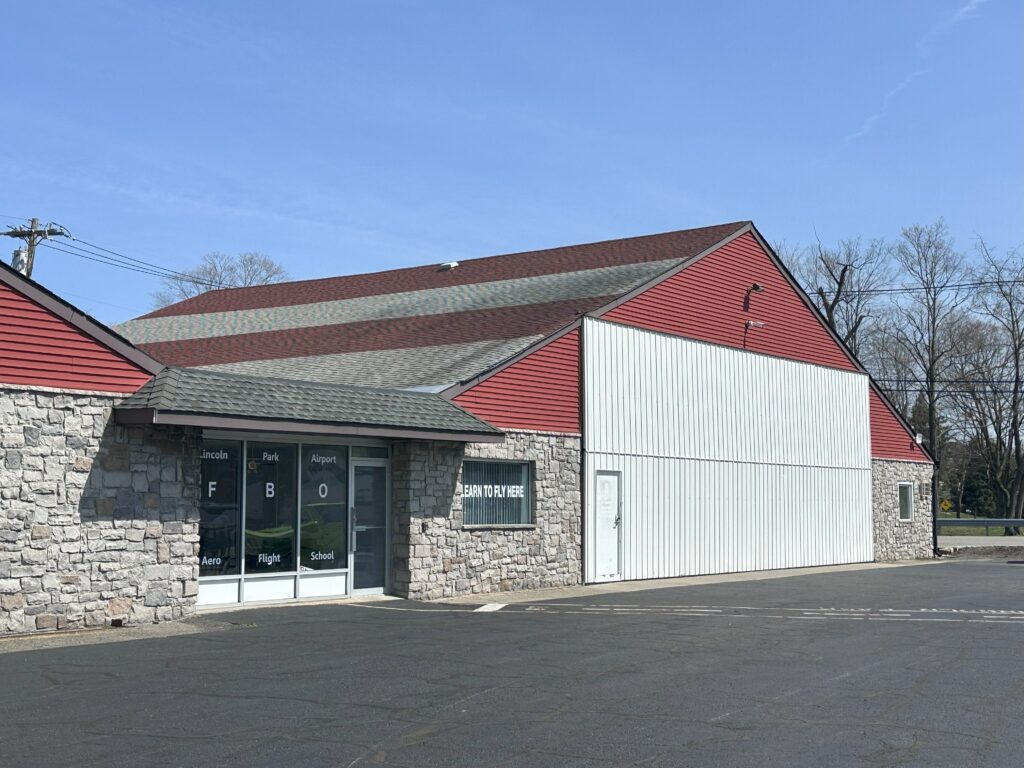 Stone building with red and gray roof.