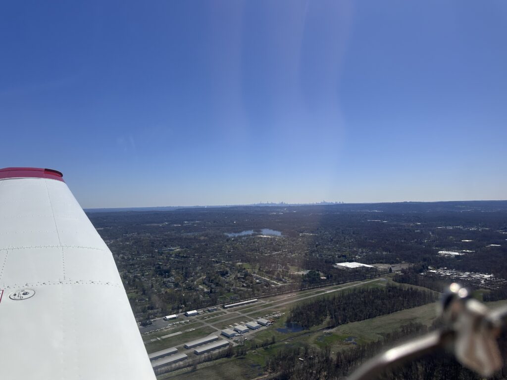 View from airplane over landscape and city skyline.
