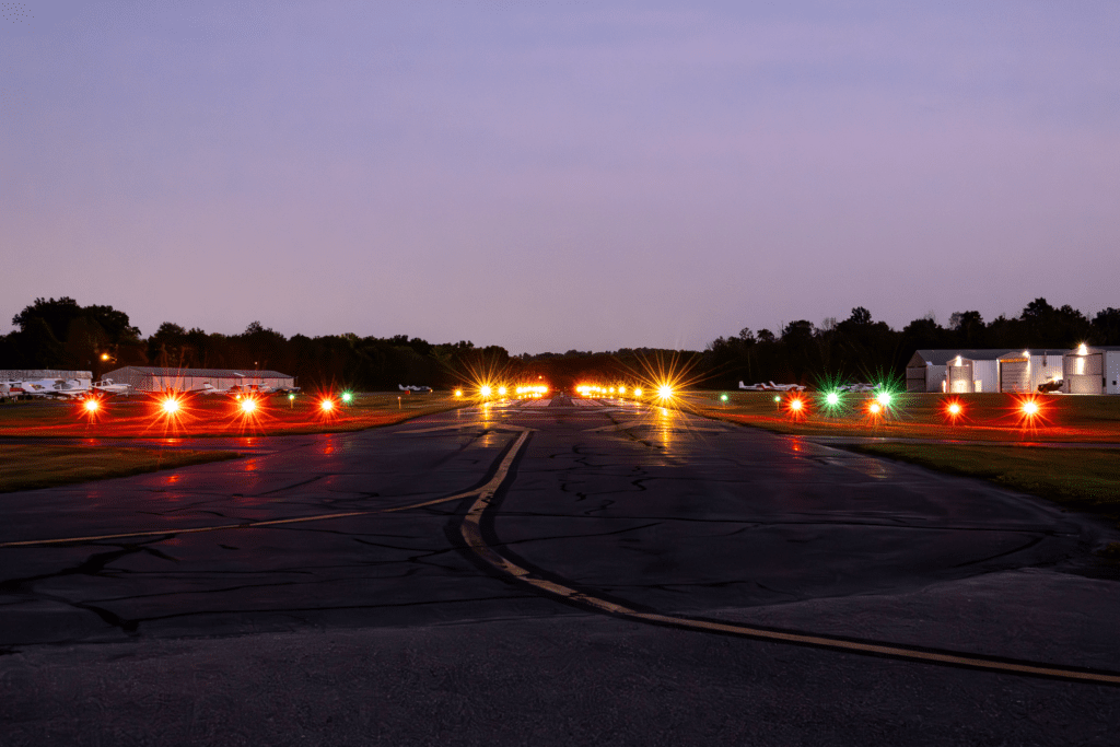 Airport runway lit up at dusk.