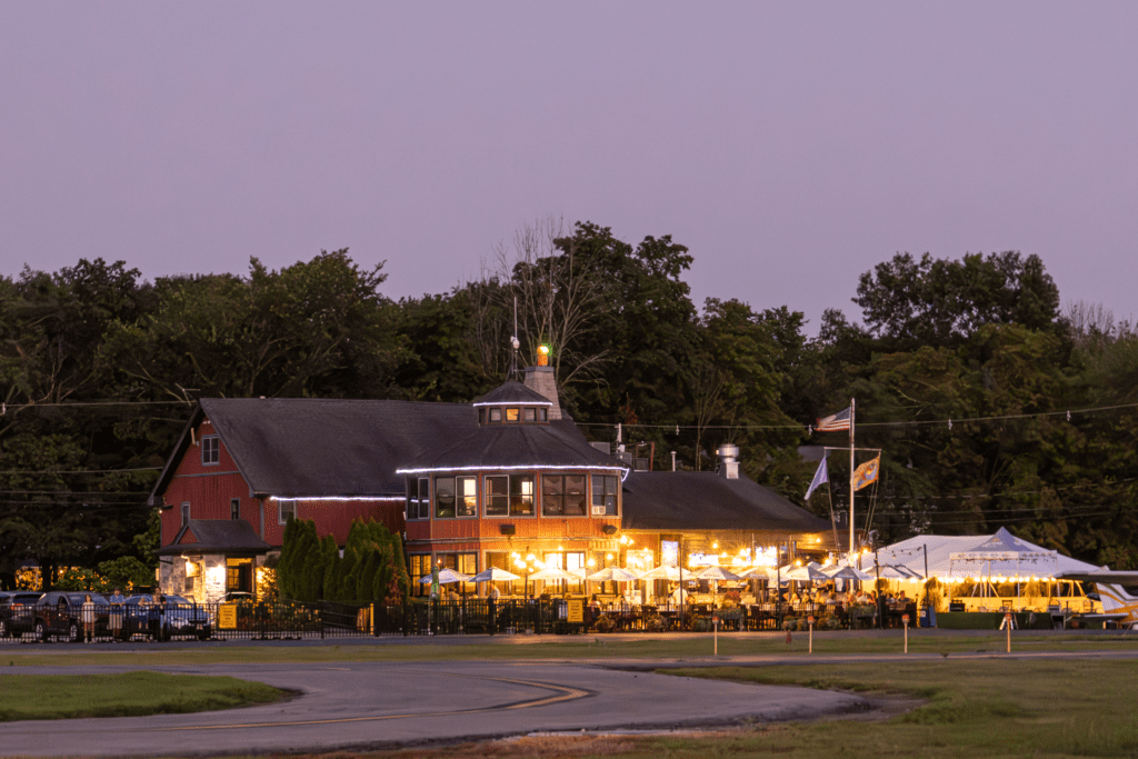 Rustic restaurant with outdoor seating at dusk.